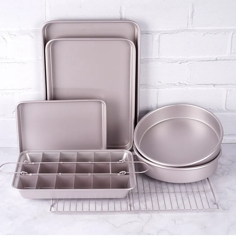 carbon steel bakeware sets with rosegold nonstick coating with three rectangle baking trays of three sizes, one brownie baking pan with divider, two round cake pans and a cooling rack