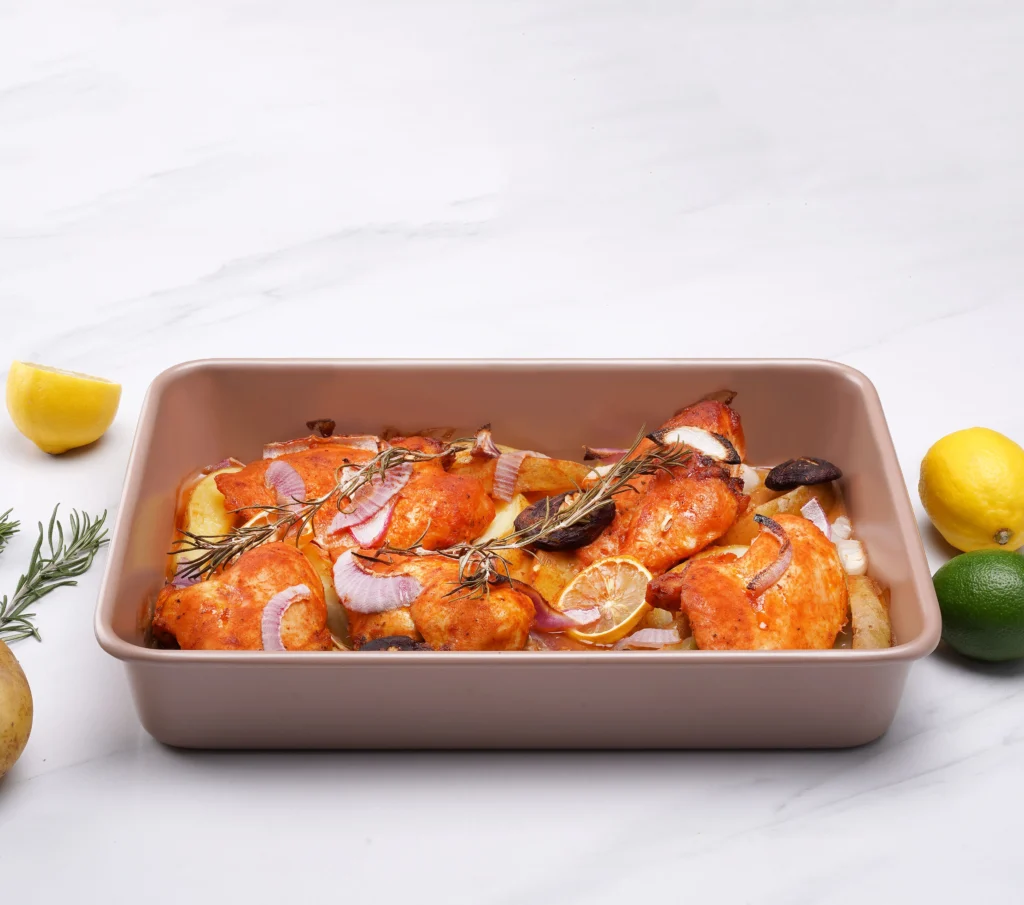 carbon steel roasting pan with nonstick champagne gold coating and roasted chicken in it